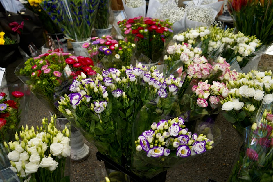 A vibrant display of fresh floral bouquets arranged on a table at Yeading Lane florist, showcasing a variety of flowers including white and purple lisianthus, pink and white roses, and multicolored ch